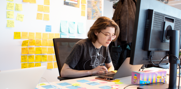 Inviqa team member Olena at her work station, surrounded by sticky notes
