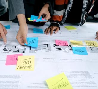 Team of people at a table with a user journey map and post it notes