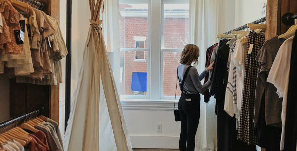 A woman browses in a clothing boutique