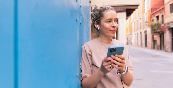 Gen Z woman engaging with her phone while exploring city