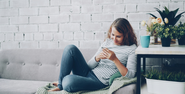 Woman sitting on a couch looking at her phone