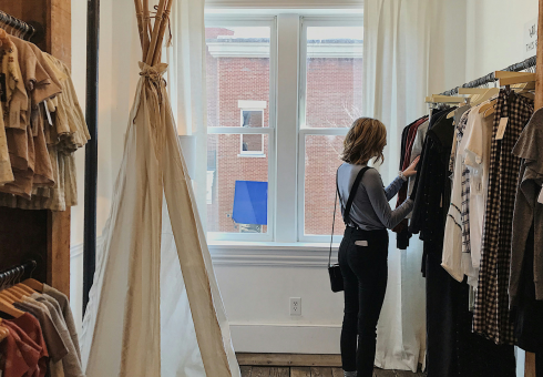 A woman browses in a clothing boutique