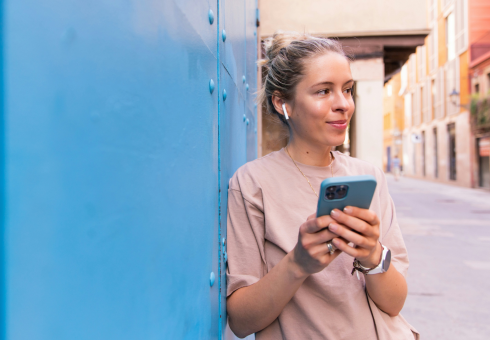 Gen Z woman engaging with her phone while exploring city