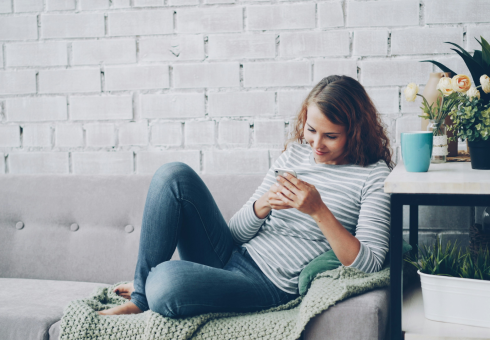 Woman sitting on a couch looking at her phone