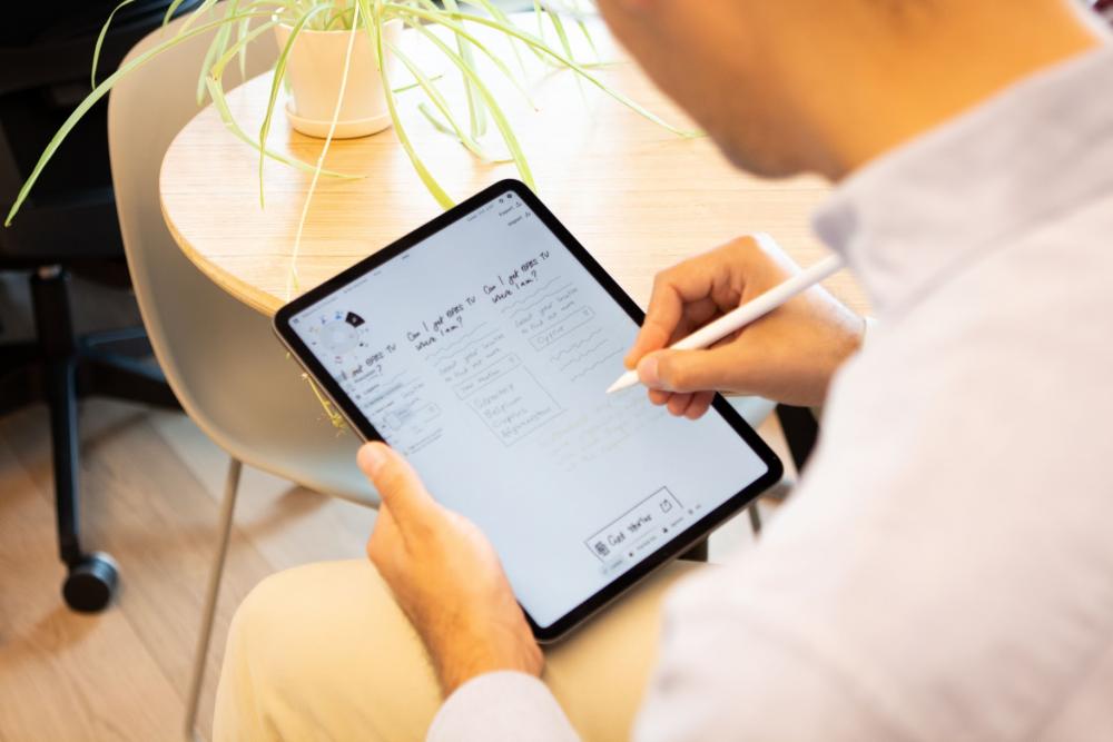 Mann, der etwas in sein iPad schreibt