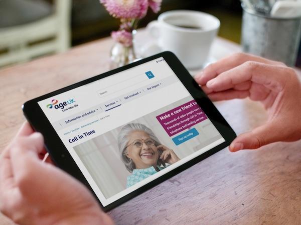 Age UK Website on tablet with user browsing