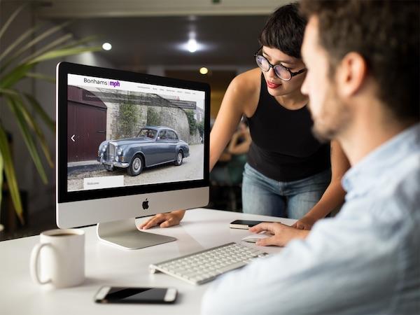 woman and man looking at car on a desktop