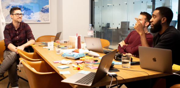Inviqa workshop in meeting room with three participants engaging in a conversation
