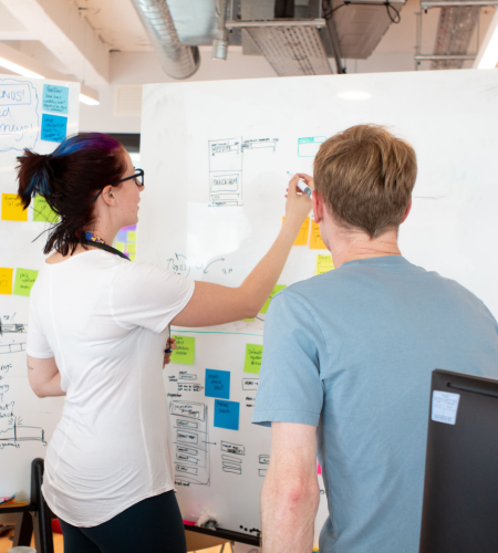 Two people at whiteboard at an online retailer company